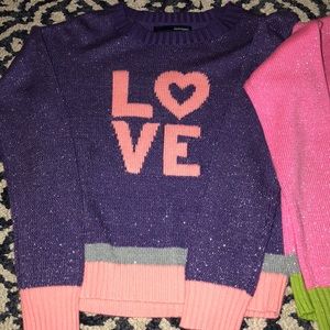 Two kids long sleeve colorful sweaters.